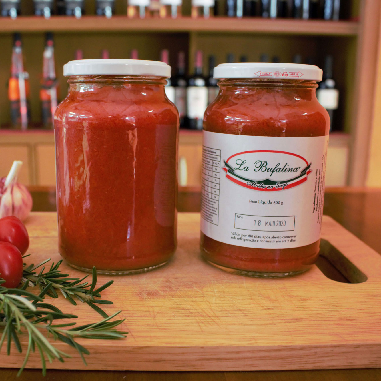 Dois potes de molho de tomate ao sugo sobre tábua